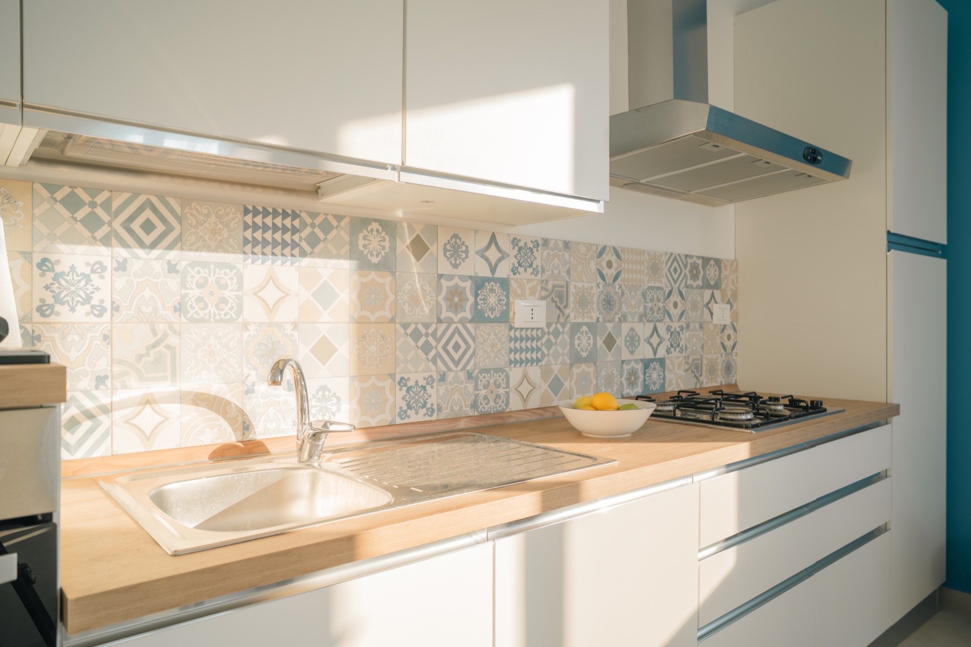 Piano cottura e lavello della cucina della Dimora Blu con parete in maioliche