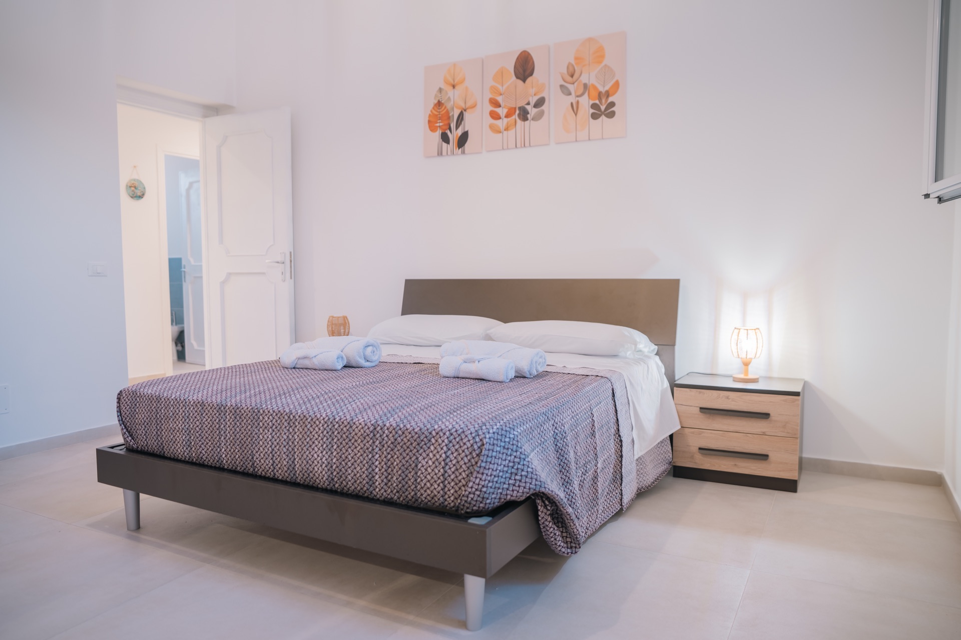 Letto matrimoniale della Dimora Verde con comodino e decorazioni